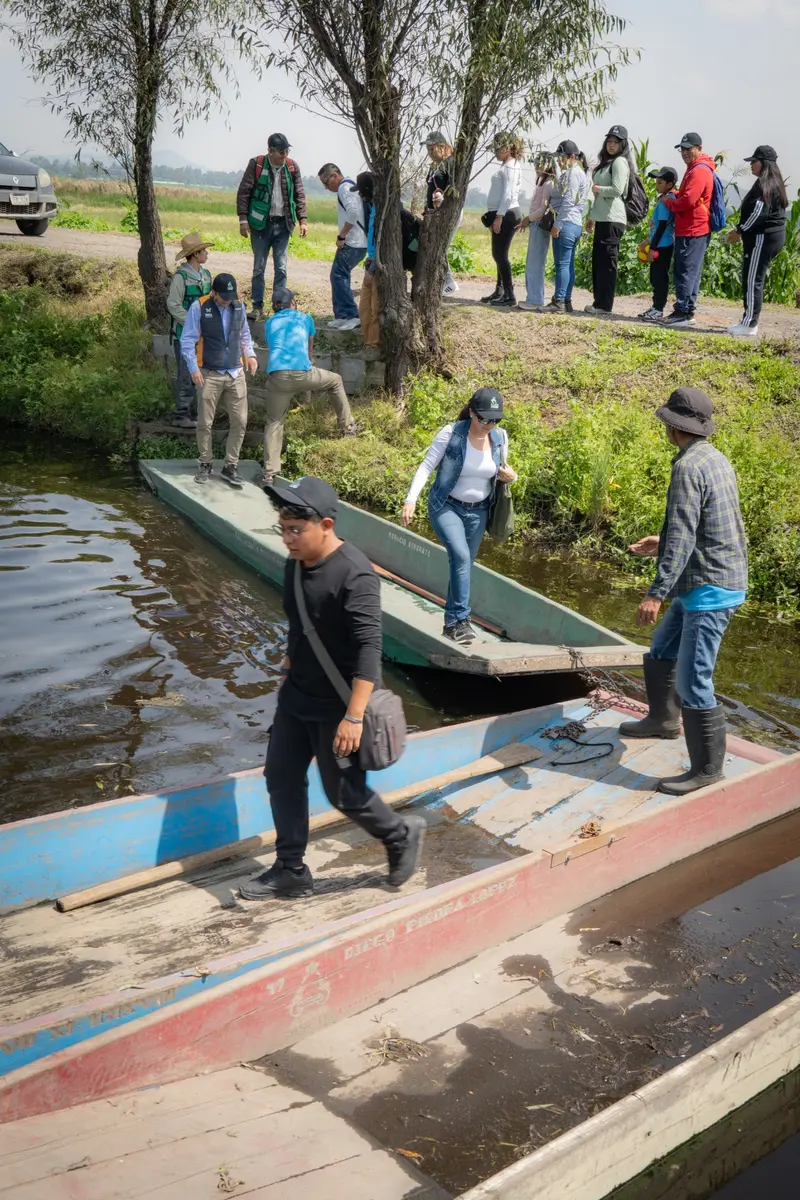 Grupo de visitantes cruzando canales en canoa en la zona chinampera